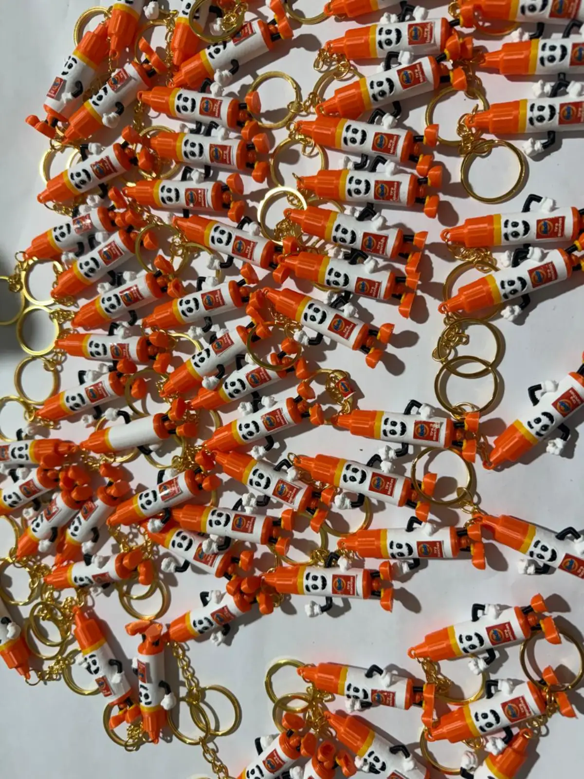 Lote de chaveiros personalizados laranja e branco sobre fundo claro